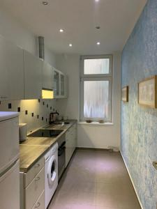 eine Küche mit einer Waschmaschine, einem Trockner und einem Fenster in der Unterkunft Monteurwohnung Bochum Wattenscheid in Bochum