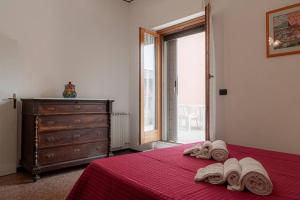 Un dormitorio con una cama roja con toallas. en La casa dei fiori 10 min dal mare, en Fano