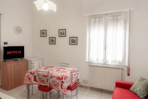 mesa de comedor con mantel rojo y blanco en La casa dei fiori 10 min dal mare, en Fano
