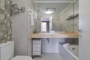 a white bathroom with a sink and a toilet at GuestReady - Living a dream in Barcelona in Barcelona