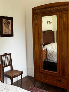 a wooden cabinet with a mirror in a bedroom at Chateau De Martigny in Poisson