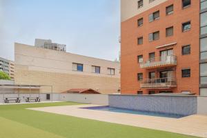 un gran edificio de ladrillo con un patio verde delante de él en GuestReady - Living a dream in Barcelona, en Barcelona