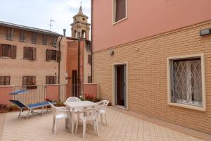 un patio con mesa y sillas y un edificio en La casa dei fiori 10 min dal mare, en Fano