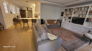 ein Wohnzimmer mit einem Sofa und einem TV in der Unterkunft Saint-Jean de Luz, bel appartement 3 pièces - 4 couchages in Sainte-Barbe