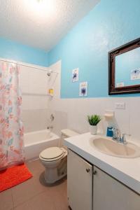 a bathroom with a toilet and a sink and a tub at Tropicabana in Nassau +14 photos