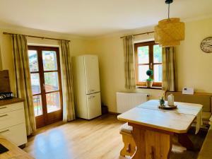 eine Küche mit einem Holztisch und einem Kühlschrank in der Unterkunft Ferienwohnung Stadlmann in St. Wolfgang