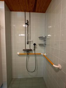 um chuveiro com uma mangueira numa casa de banho com azulejos em Grand Hostel Imatra em Imatra