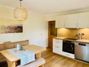 eine Küche mit weißen Schränken und einem Holztisch in der Unterkunft Ferienwohnung Stadlmann in St. Wolfgang + 8 Fotos