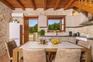 a kitchen and dining room with a table and chairs at Villa Luciana by Villa Plus in Koiliomenos