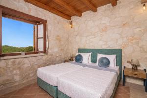 a bedroom with a bed in a stone wall at Villa Luciana by Villa Plus in Koiliomenos