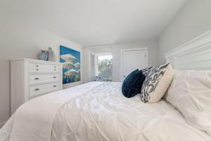 シーブルック・アイランドにある1306 Pelican Watch Villaの白いベッドルーム(青い枕の白いベッド付)