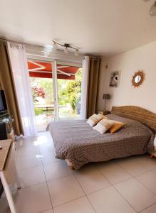 a bedroom with a bed and a sliding glass door at Chambre d'hôte Kalango proche de la plage-Piscine in Lucciana