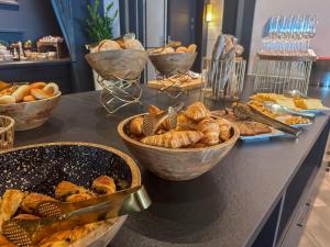 a counter with bowls of bread and baskets of pastries at Van der Valk Hotel Spa in Spa