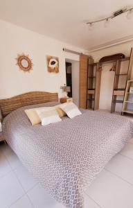 een slaapkamer met een groot bed met kussens erop bij Chambre d'hôte Kalango proche de la plage-Piscine in Lucciana