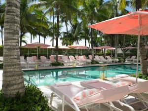 a swimming pool with lounge chairs and umbrellas at Grand Beach Hotel in Miami Beach