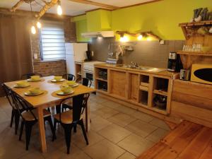 una cocina con mesa de madera y sillas. en La Ferme du Pré Charmant, en Grandhan
