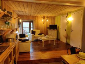 sala de estar con paredes y suelo de madera en La Ferme du Pré Charmant, en Grandhan