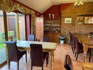 comedor con mesa de madera y sillas en Willow Tree Cottages, en Newark-on-Trent