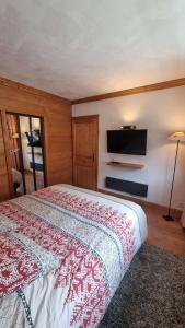 Schlafzimmer mit einem Bett und einem Flachbild-TV in der Unterkunft Lodge 1 : Magnifique deux chambres proche centre in Morzine