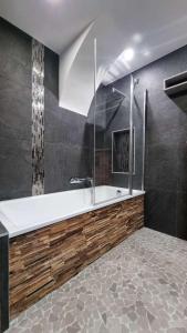 ein großes Bad mit einer Badewanne und einer Dusche in der Unterkunft Lodge 1 : Magnifique deux chambres proche centre in Morzine