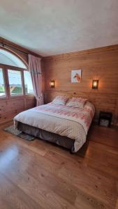 ein Schlafzimmer mit einem Bett in einem Zimmer mit Holzwänden in der Unterkunft Lodge 1 : Magnifique deux chambres proche centre in Morzine