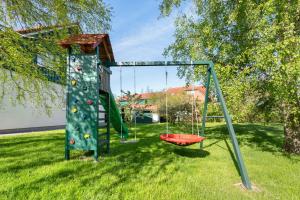 a playground in a yard with a swing at Feriendoppelhaus Sommer in Stakendorf