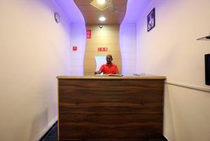 a man sitting at a counter in a room at Hotel Parkash Inn in Jalandhar