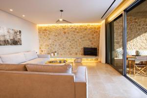 a living room with a couch and a tv at Villa Lavender Bloom by Villa Plus in Sivota