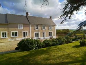 a large house with a large lawn in front of it at Au Fil De L'Aure in Monfréville