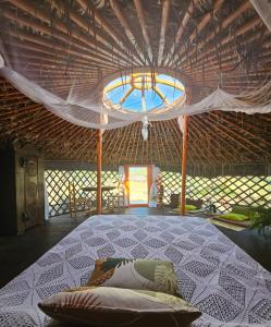 a bedroom with a large bed in a straw hut at Yurta Bora Bora in L'Ametlla de Mar