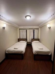 a room with two beds in a room with at Taleju Grand Hotel in Bhaktapur