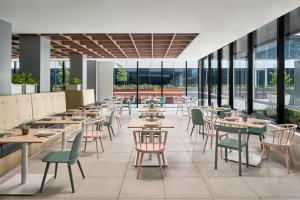 a restaurant with tables and chairs and windows at Element Melbourne Richmond in Melbourne