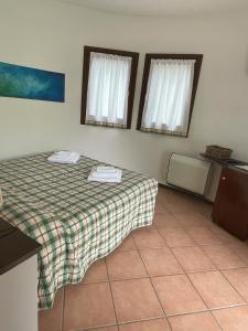 a room with a bed and two windows in it at Agriturismo La Lupa in Madonna della Provvidenza