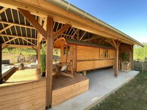 a large wooden cabin with a large roof at Chaignonnières Roulotte 19pers jacuzzi 15min mer in La Chaise-Beaudouin