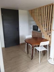 einen Tisch und Stühle in einem Zimmer mit einer Treppe in der Unterkunft La Rose du Bel Homme in Rocroi