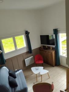 ein Wohnzimmer mit einem Sofa und einem TV in der Unterkunft La Rose du Bel Homme in Rocroi