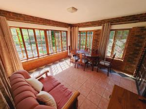 a living room with a couch and a table at Gorgeous Garden Villa in Gillitts-Emberton