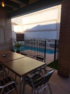 a patio with tables and chairs and a swimming pool at Casas Rurales El Aljibe, Jara in Argés