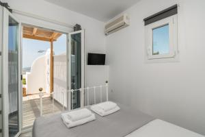 una camera da letto bianca con un letto e un balcone di Clara Terra a Mytakas