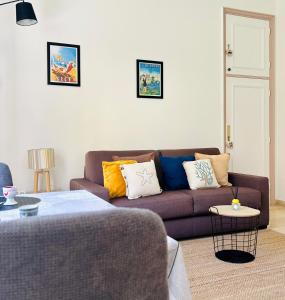 - un salon avec un canapé marron et des oreillers colorés dans l'établissement Charmant Studio en bord de Mer, à Nice