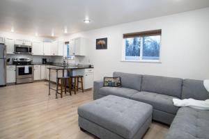 a living room with a couch and a kitchen at Northern Lights Getaway Minutes to Ft Wainwright in North Pole