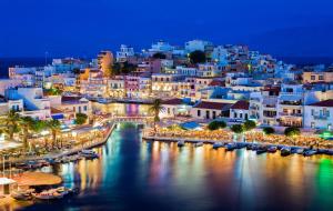 een uitzicht op een stad 's nachts met boten in het water bij Nicol studio for two center of Agios Nikolaos in Agios Nikolaos