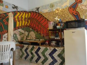 a kitchen with a mosaic wall with a refrigerator at Casa Vista Al Mar - Iguana Room in Puerto Escondido