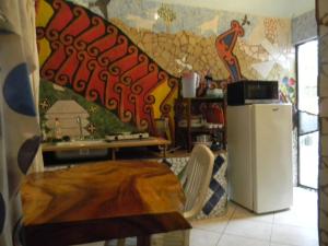 a room with a refrigerator and a wall with a mural at Casa Vista Al Mar - Iguana Room in Puerto Escondido