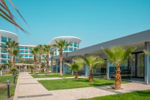 a building with palm trees in front of it at Sultan of Dreams Hotel & Spa in Kızılot