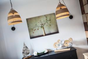 two pendant lights hanging above a dresser with a painting at Hotel Zerrenpach Látky in Látky