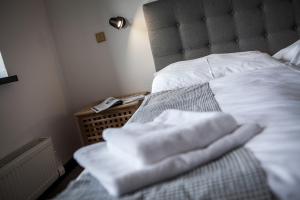 - un lit avec des serviettes blanches assises au-dessus dans l'établissement Hotel Zerrenpach Látky, à Látky