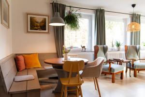 een woonkamer met een tafel en stoelen en een bank bij Forellenhof Wald- und Wiesenquartier in Bad Berleburg