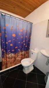 a bathroom with a toilet and a shower curtain at Hotel san Jorge in Melgar