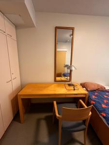 a bedroom with a desk with a mirror and a bed at Grand Hostel Imatra in Imatra
